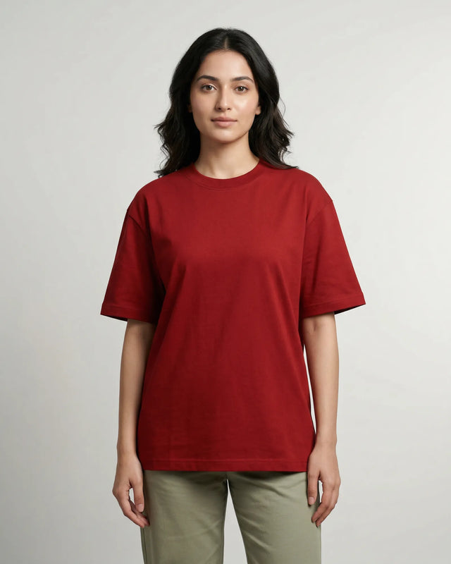 Woman wearing a red t-shirt and green pants on a plain background