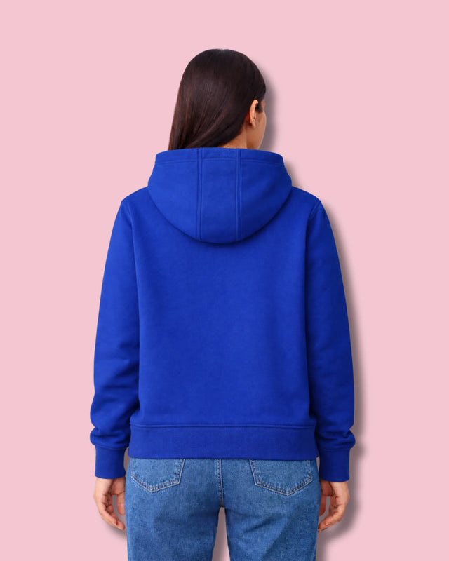 Person wearing a royal blue hoodie on a pink background