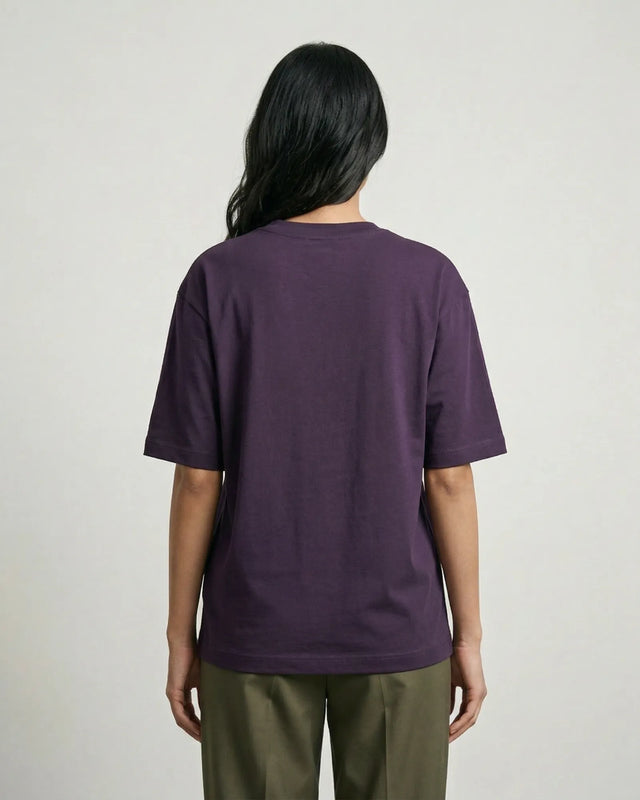 Person wearing a purple t-shirt and green pants on a plain background