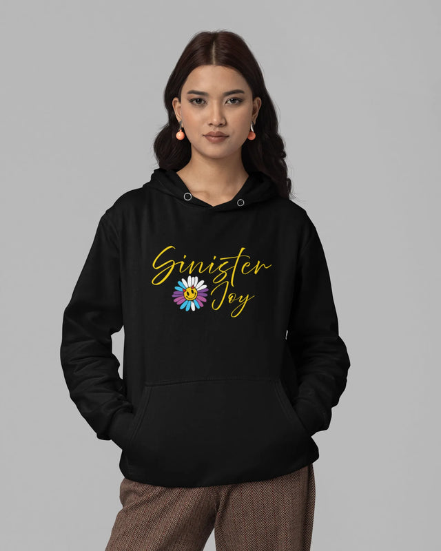 Woman wearing a black hoodie with 'Sinister Joy' text and flower graphic on a gray background
