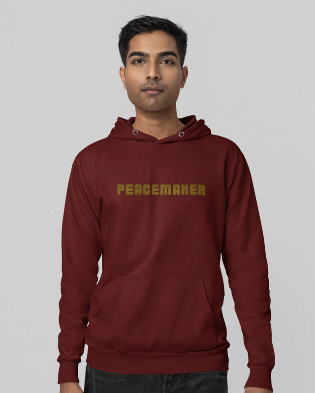 Person wearing a maroon hoodie with 'PEACEMAKER' text on a plain background