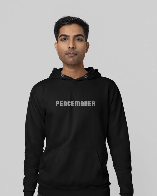 Person wearing a black hoodie with 'PEACEMAKER' text on a gray background