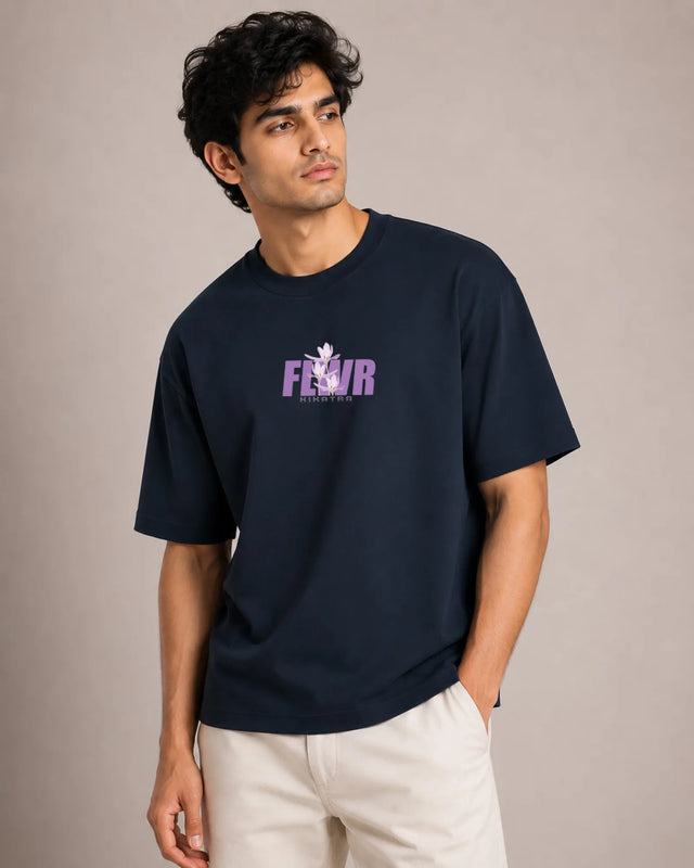 Man wearing a navy blue t-shirt with a logo and text on a beige background