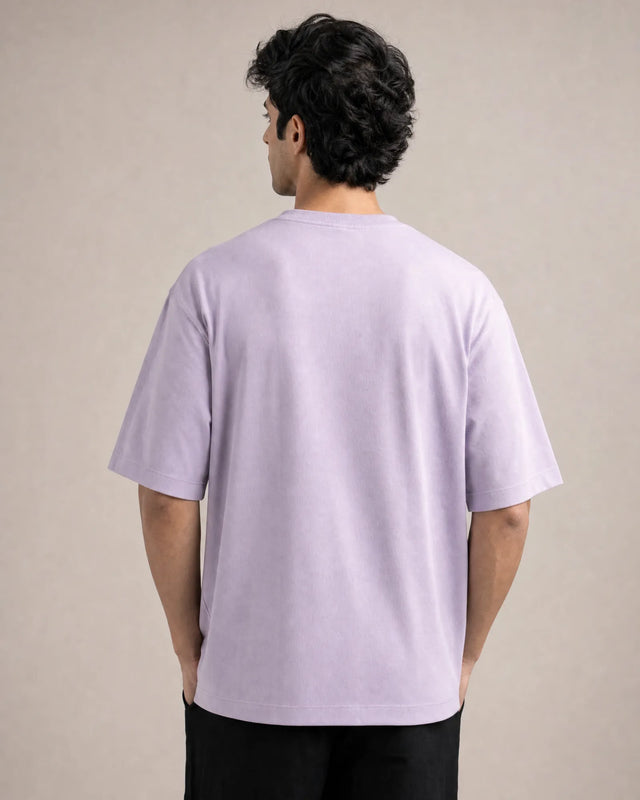 Person wearing a light lavender t-shirt against a beige background
