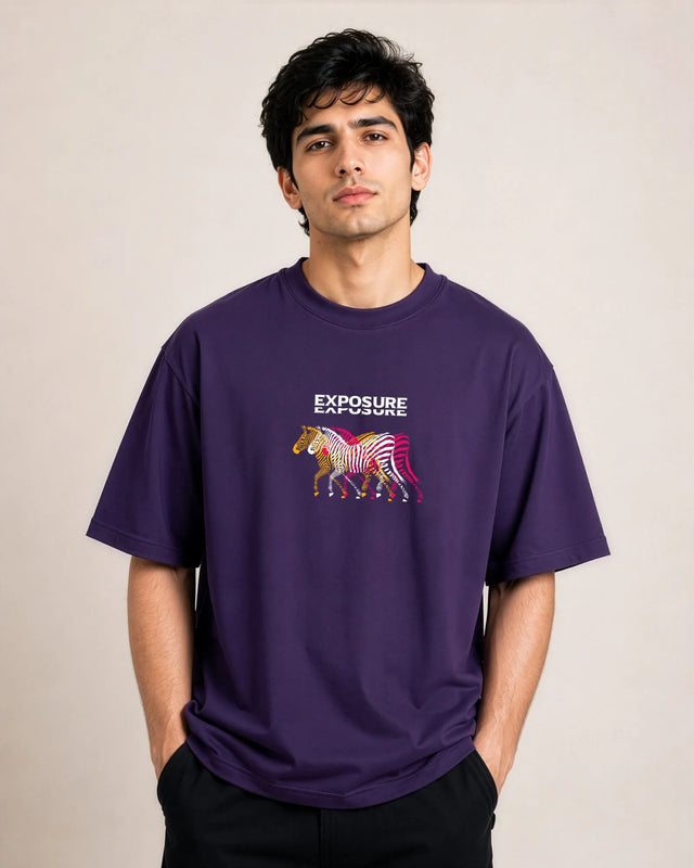 Man wearing a purple t-shirt with a colorful zebra graphic and 'Exposure' text on a beige background