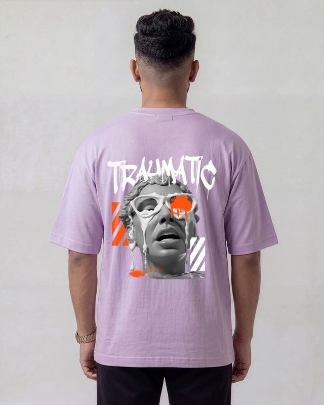 Person wearing a lavender t-shirt with graphic design and text on the back, against a plain background