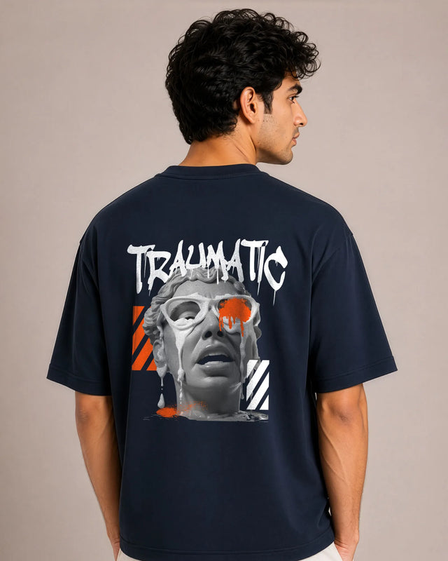 Person wearing a navy blue t-shirt with a graphic design on the back against a beige background