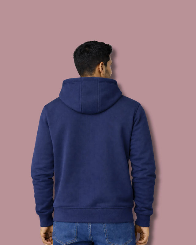 Person wearing a blue hoodie against a pink background