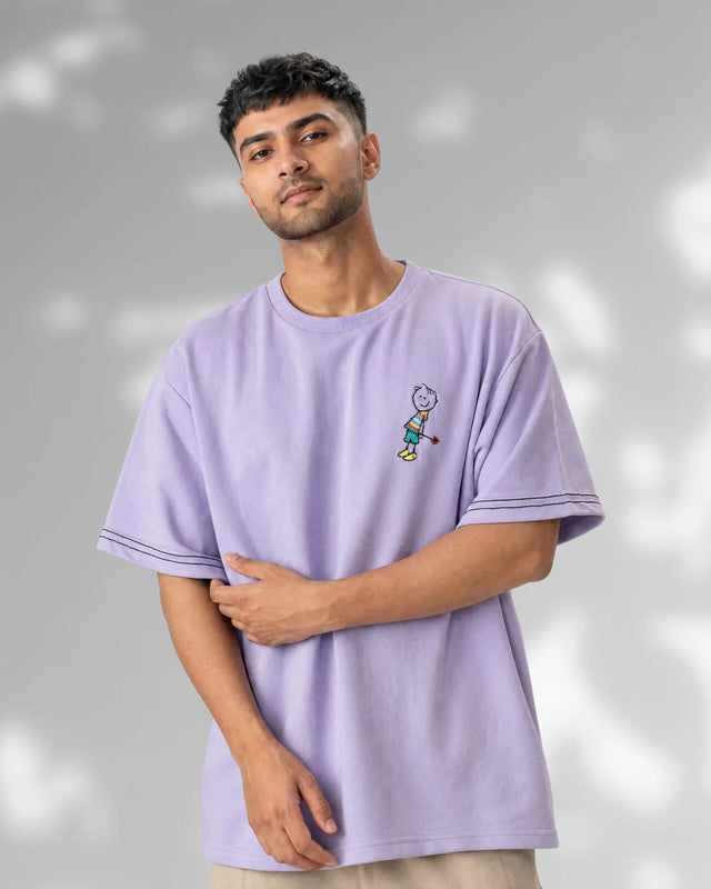 Man wearing a light purple t-shirt with a small graphic on a gray background