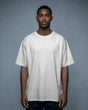 Man wearing a plain white t-shirt against a gray background
