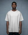 Man wearing a plain white t-shirt against a gray background