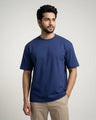 Man wearing a royal blue t-shirt against a plain background
