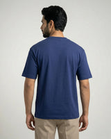 Man wearing a royal blue t-shirt on a plain background