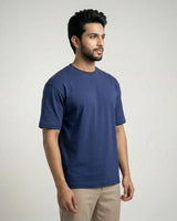 Man wearing a royal blue t-shirt against a plain background