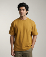 Man wearing a mustard yellow t-shirt against a plain background
