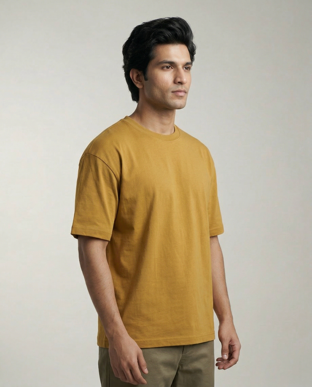 Man wearing a mustard yellow t-shirt against a plain background