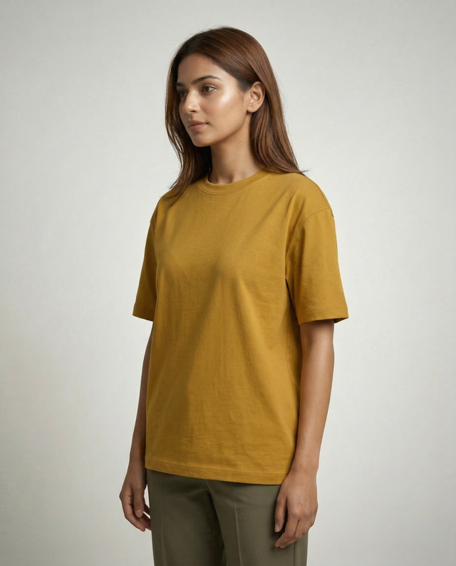 Woman wearing a mustard yellow t-shirt against a plain background