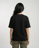 woman wearing a black t-shirt on a plain background