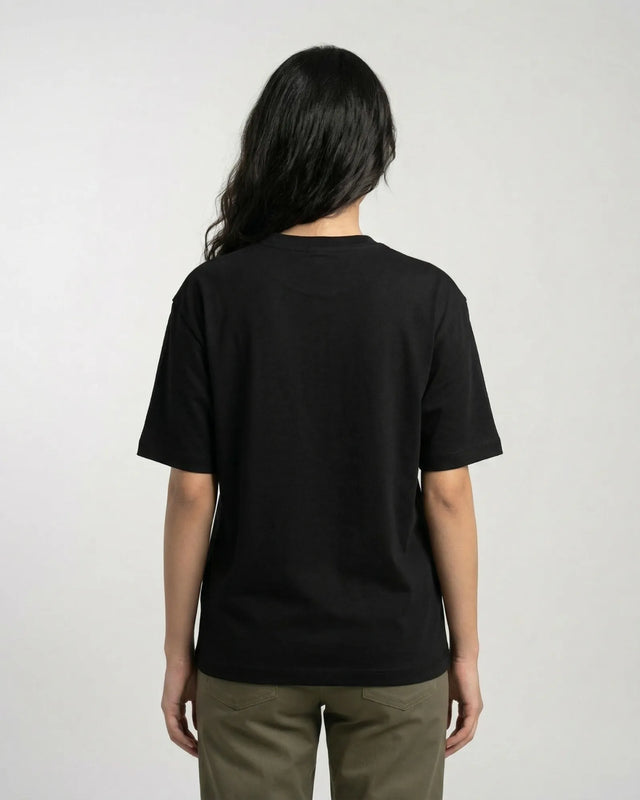 woman wearing a black t-shirt on a plain background
