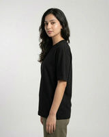 Woman wearing a black t-shirt against a plain background