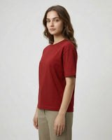 Woman wearing a red t-shirt and beige pants on a white background