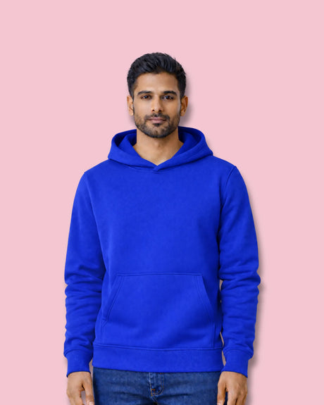 Man wearing a royal blue hoodie against a pink background