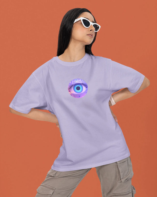 Person wearing a light purple t-shirt with a colorful eye design on an orange background