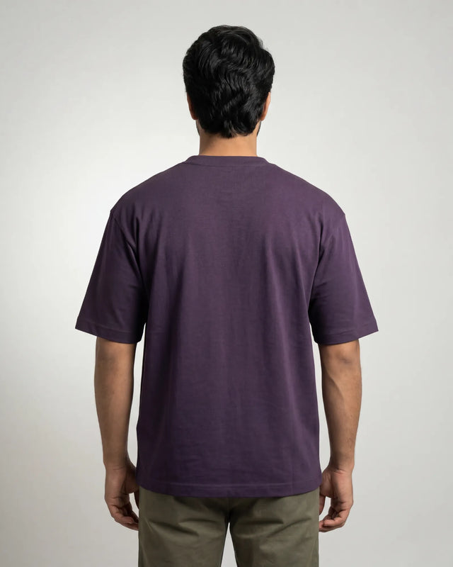 Person wearing a purple t-shirt against a plain background