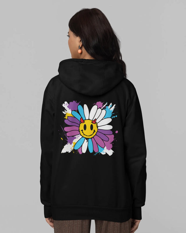 Woman wearing a black hoodie with a colorful flower design on the back against a gray background