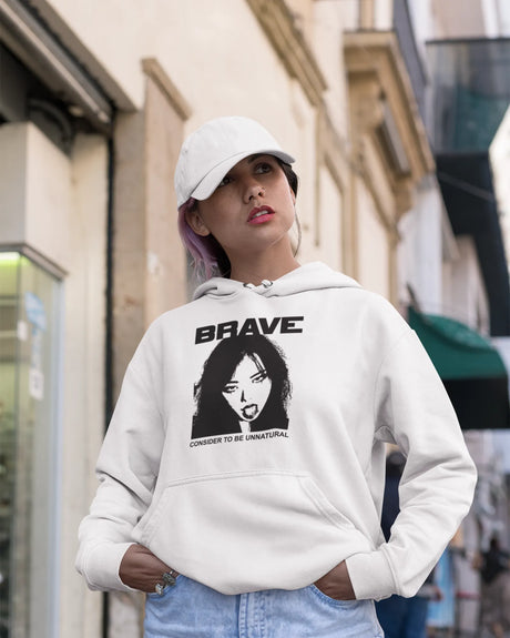 Woman wearing a white hoodie with a graphic design and text, standing on a street.