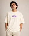 Man wearing a off-white t-shirt with a purple logo on a plain background