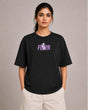Person wearing a black t-shirt with a purple logo on a plain background