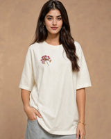 Woman wearing a Off-White t-shirt with a floral design on a beige background