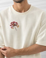 Off-White t-shirt with embroidered flower design on a plain background