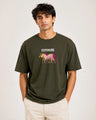 Man wearing a green t-shirt with a graphic design and text on a plain background