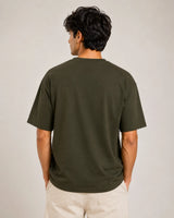 Person wearing a green t-shirt against a plain background