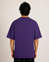 Person wearing a purple t-shirt against a plain background