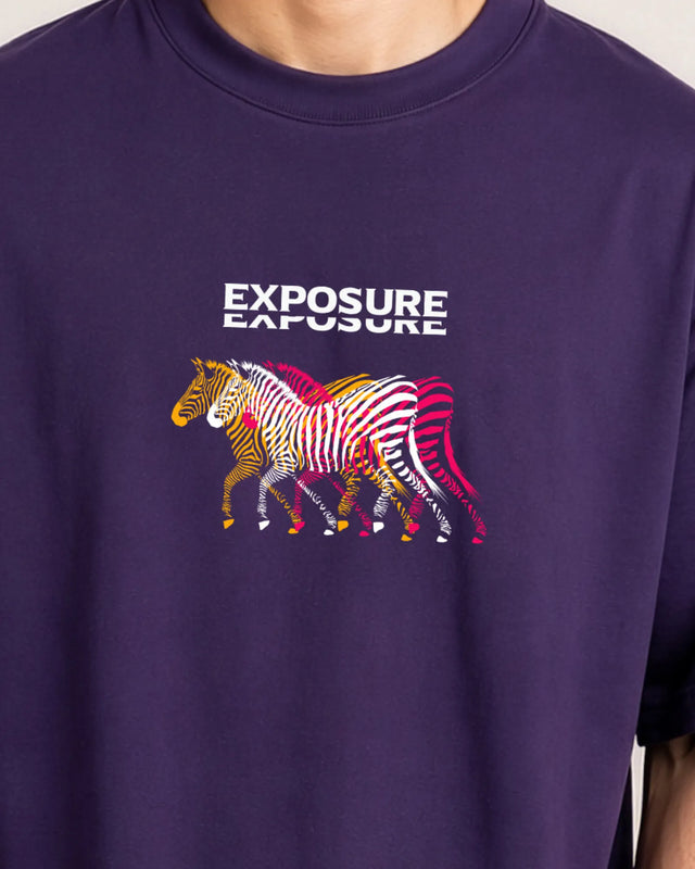 Purple t-shirt with colorful zebra design and 'Exposure' text on a plain background