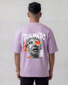 Person wearing a lavender t-shirt with graphic design and text on the back, against a plain background