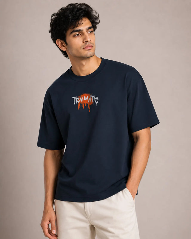 Man wearing a navy blue t-shirt with a logo and text on a beige background