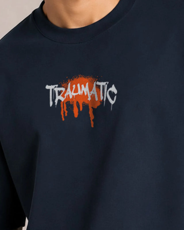 Navy blue sweatshirt with 'TRAUMATIC' text and orange splashes on a neutral background