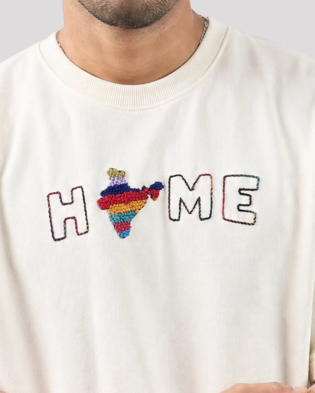 White sweatshirt with colorful 'HOME' design featuring a heart and rainbow colors.