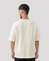 Man wearing a plain white t-shirt against a light gray background