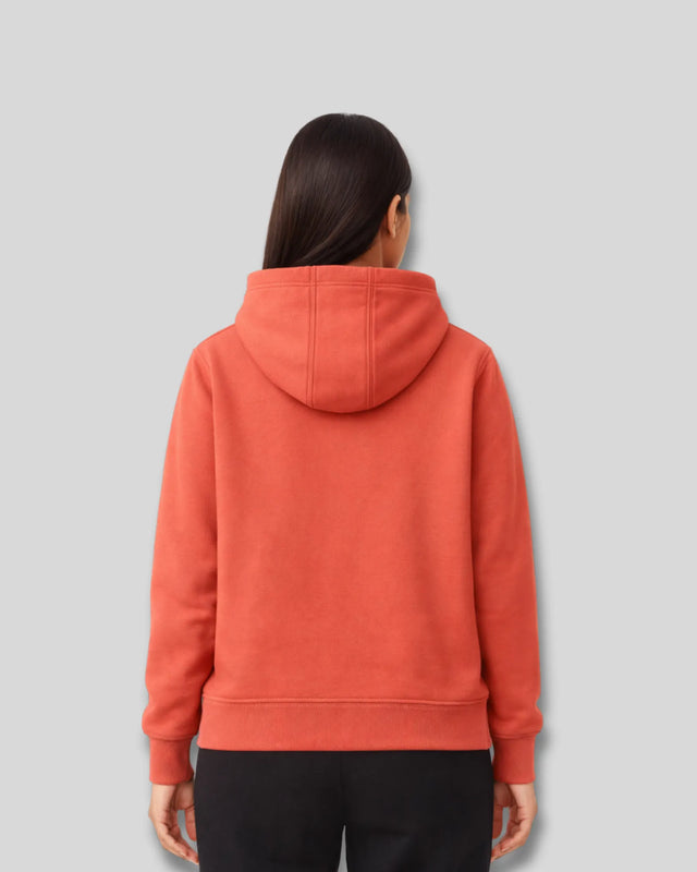 Person wearing an coral hoodie on a gray background