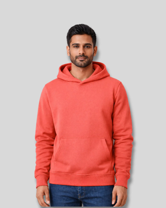 Man wearing a coral hoodie against a gray background