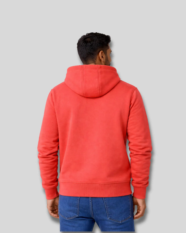 Person wearing a coral hoodie from behind on a gray background