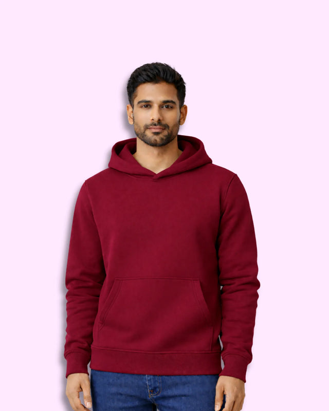Man wearing a maroon hoodie on a pink background