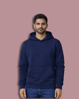 Man wearing a navy blue hoodie on a pink background