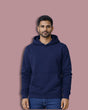 Man wearing a navy blue hoodie on a pink background