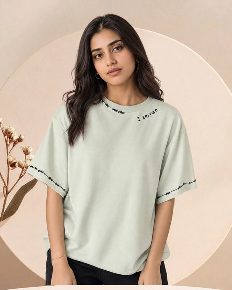Woman wearing a light green t-shirt with text on a beige background